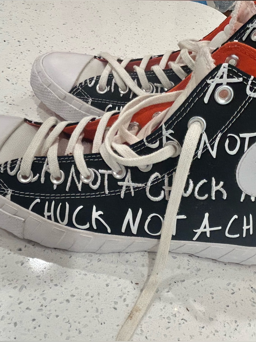 Converse High-Top Canvas Sneakers in Black & White with Orange inside.